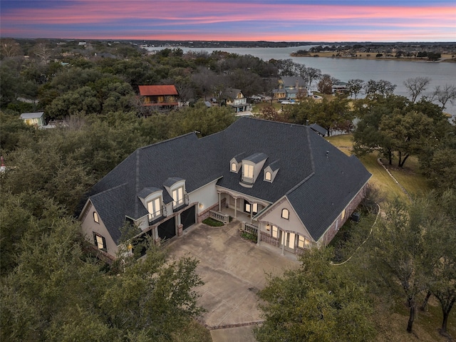 aerial view at dusk featuring a water view