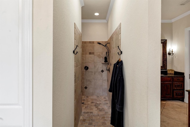 bathroom with crown molding, vanity, and a tile shower