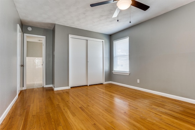 unfurnished bedroom with a closet, ceiling fan, and light wood-type flooring