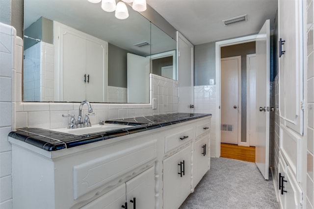 bathroom featuring vanity and decorative backsplash