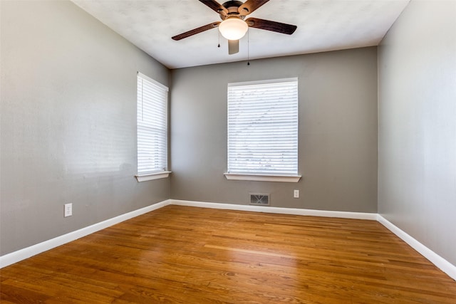 empty room with hardwood / wood-style flooring and ceiling fan