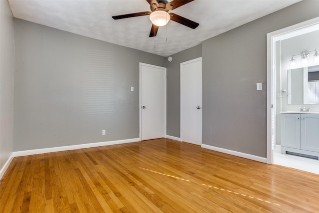 interior space featuring ceiling fan, sink, and light wood-type flooring