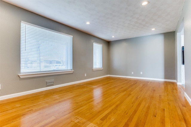 empty room featuring plenty of natural light and light hardwood / wood-style flooring