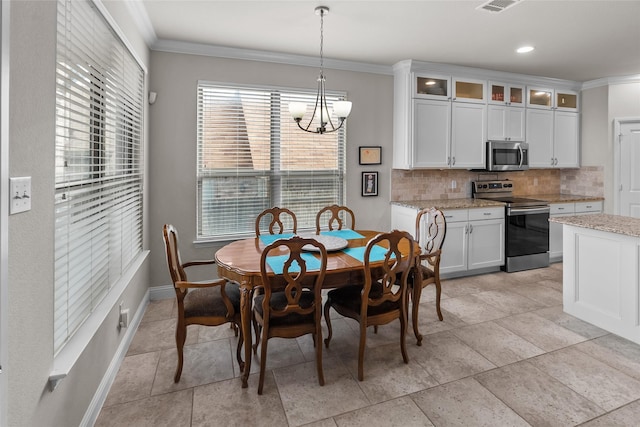 dining area featuring crown molding and a notable chandelier