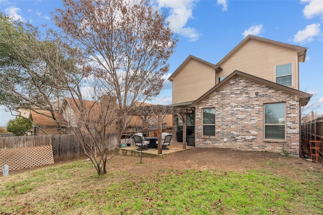 rear view of house with a yard, a pergola, and a patio