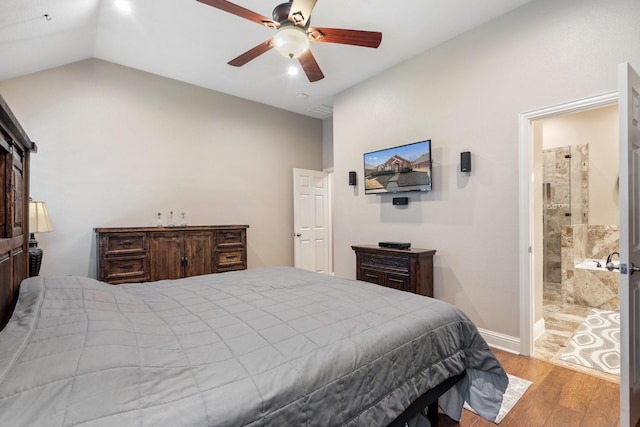 bedroom featuring lofted ceiling, ensuite bath, light hardwood / wood-style flooring, and ceiling fan