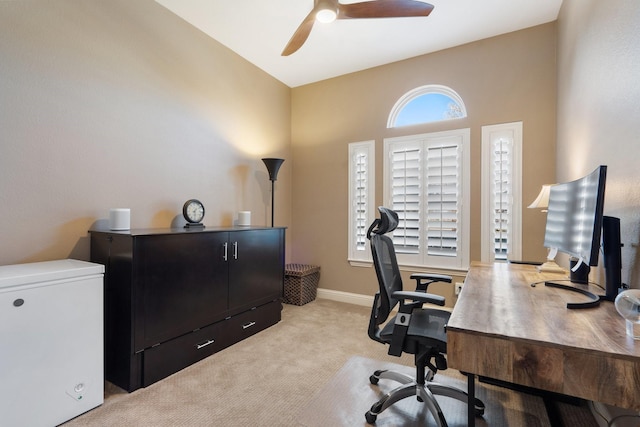 office area featuring lofted ceiling, light carpet, and ceiling fan