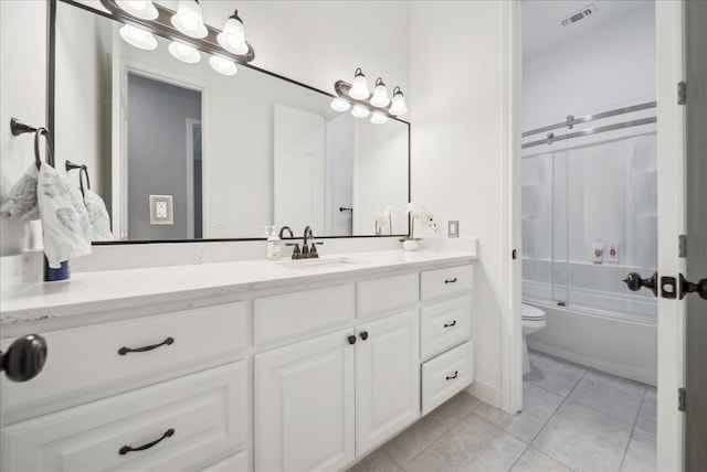 full bathroom with vanity, bath / shower combo with glass door, tile patterned floors, and toilet