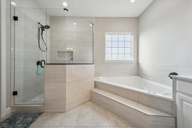 bathroom featuring tile patterned flooring, a bath, a stall shower, and vanity
