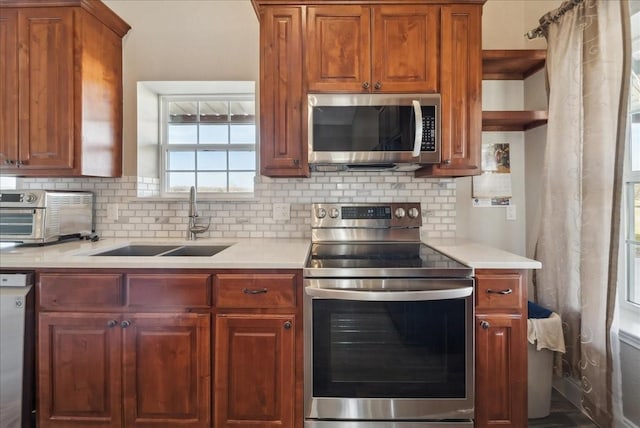 kitchen featuring a sink, appliances with stainless steel finishes, a toaster, and light countertops