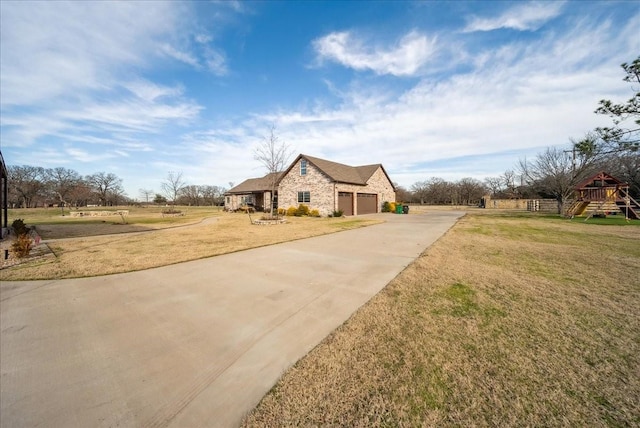 view of front of house with a garage, a playground, and a front yard