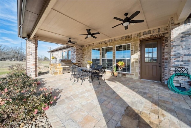 view of patio / terrace featuring outdoor dining area, ceiling fan, area for grilling, and an outdoor kitchen