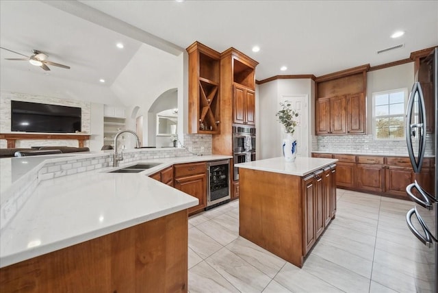 kitchen featuring visible vents, freestanding refrigerator, beverage cooler, tasteful backsplash, and a sink