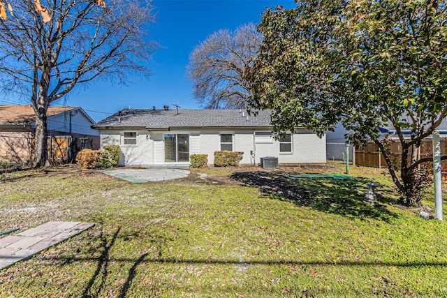 rear view of property featuring central AC unit, a lawn, and a patio