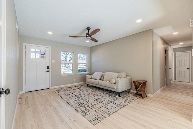 living room featuring ceiling fan and light hardwood / wood-style flooring