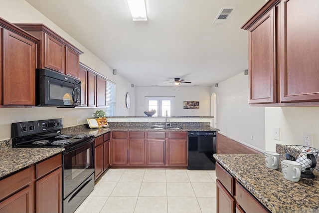 kitchen featuring sink, ceiling fan, black appliances, light tile patterned flooring, and dark stone counters