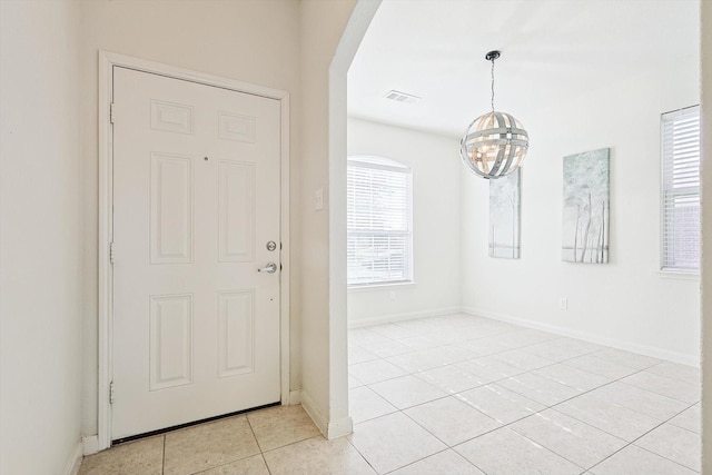 tiled entryway with an inviting chandelier