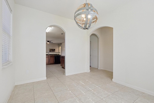 tiled empty room featuring ceiling fan with notable chandelier