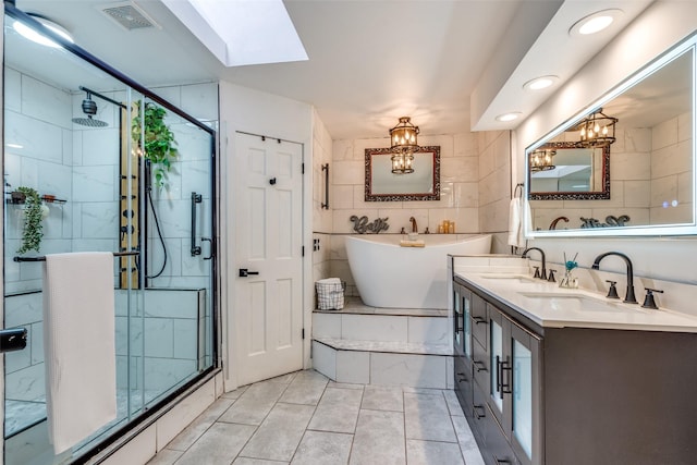 bathroom featuring a skylight, vanity, independent shower and bath, and tile walls