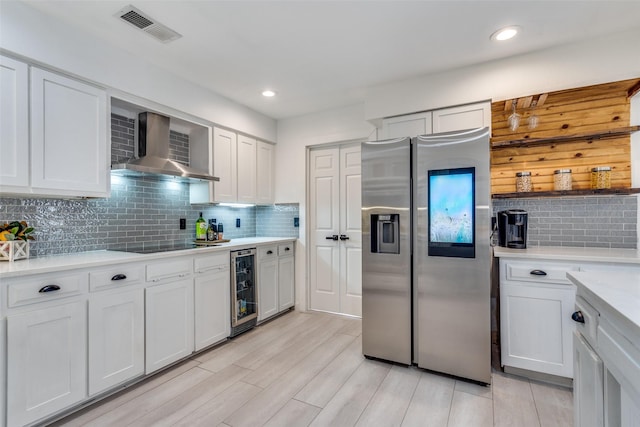 kitchen featuring white cabinetry, wine cooler, stainless steel fridge, and wall chimney exhaust hood