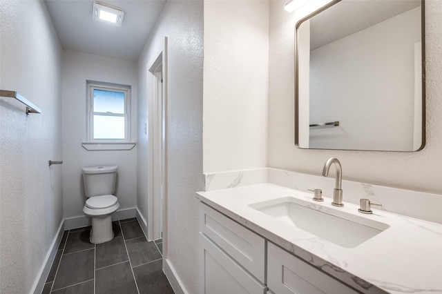 bathroom featuring vanity, tile patterned floors, and toilet