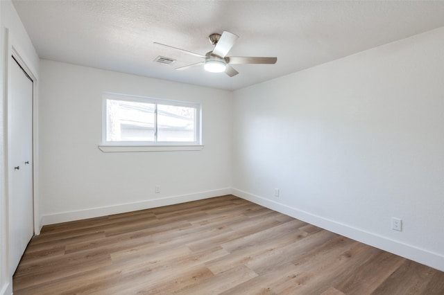 unfurnished bedroom featuring light hardwood / wood-style flooring, ceiling fan, and a closet