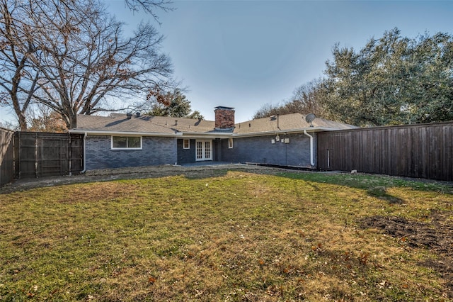 back of house with french doors and a lawn