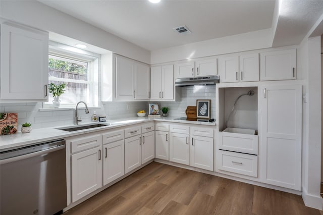 kitchen with dishwasher, sink, white cabinets, and backsplash