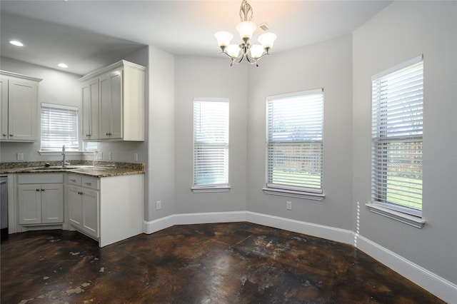 kitchen with hanging light fixtures, white cabinetry, sink, and a healthy amount of sunlight