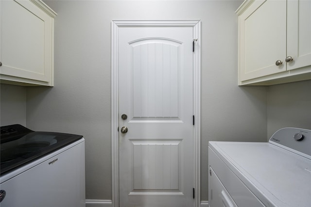 laundry area featuring washer and clothes dryer and cabinets