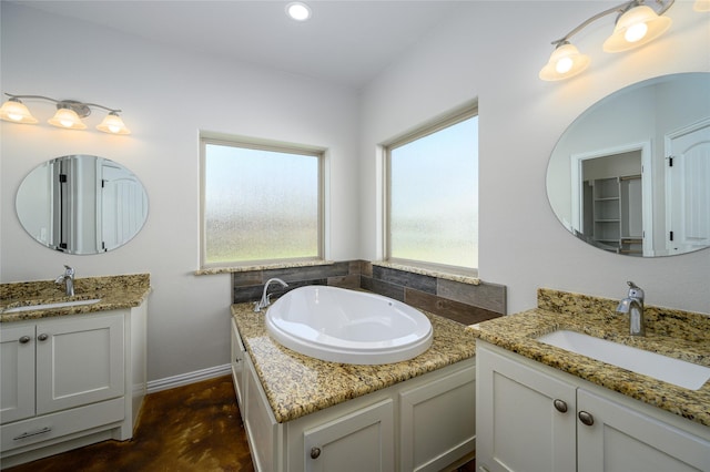 bathroom featuring vanity, a tub, and concrete floors