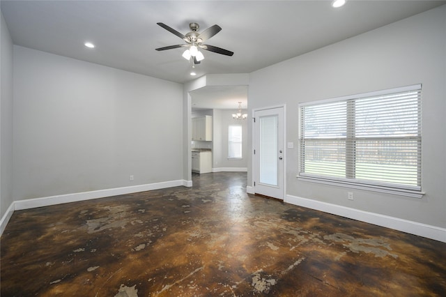 unfurnished living room with ceiling fan with notable chandelier