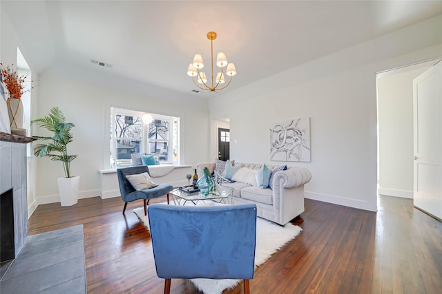 living room with visible vents, baseboards, a fireplace with flush hearth, dark wood-style flooring, and an inviting chandelier