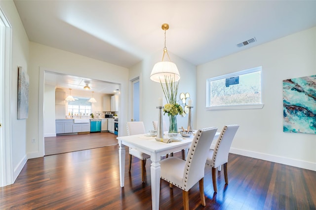 dining area with dark wood-style floors, baseboards, and visible vents