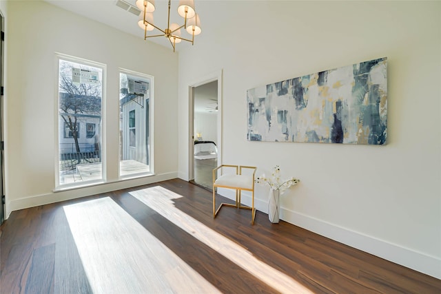 living area featuring an inviting chandelier, visible vents, baseboards, and dark wood finished floors