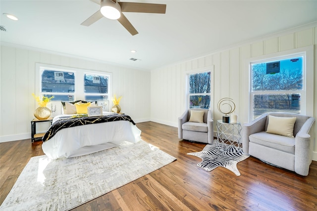 bedroom with crown molding, ceiling fan, and dark hardwood / wood-style flooring