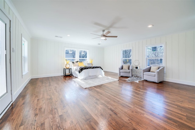 bedroom featuring multiple windows, dark hardwood / wood-style floors, and ceiling fan