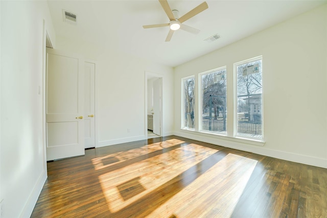 unfurnished bedroom featuring hardwood / wood-style floors, visible vents, and baseboards