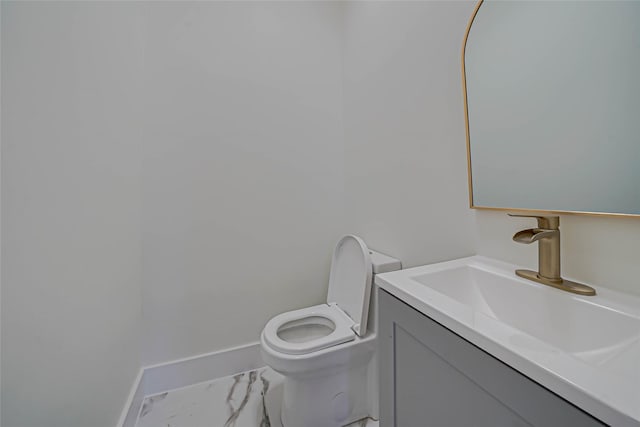 bathroom featuring marble finish floor, toilet, vanity, and baseboards