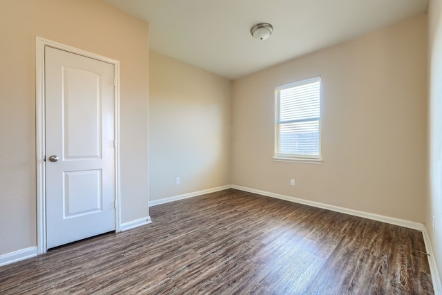 unfurnished room with dark hardwood / wood-style flooring