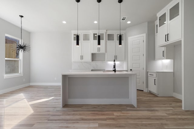 kitchen with white cabinetry, sink, and pendant lighting