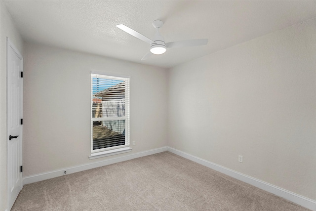 carpeted spare room featuring ceiling fan and a textured ceiling