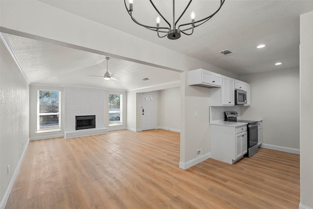 kitchen featuring light hardwood / wood-style flooring, stainless steel appliances, white cabinets, a textured ceiling, and ceiling fan with notable chandelier