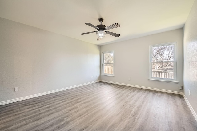 spare room with ceiling fan, hardwood / wood-style flooring, and a healthy amount of sunlight