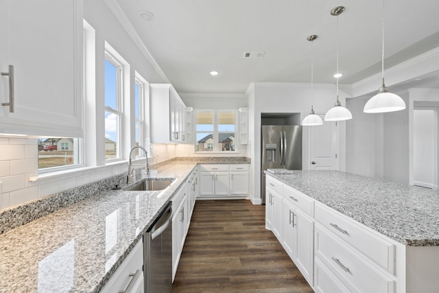 kitchen with tasteful backsplash, sink, white cabinetry, and appliances with stainless steel finishes