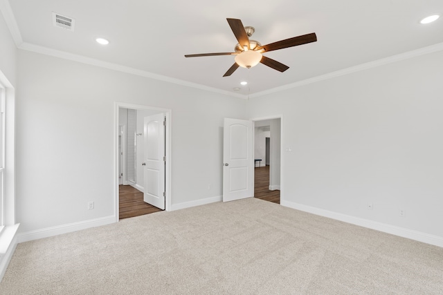 unfurnished bedroom featuring dark carpet, crown molding, and ceiling fan