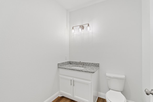 bathroom featuring vanity, hardwood / wood-style floors, and toilet