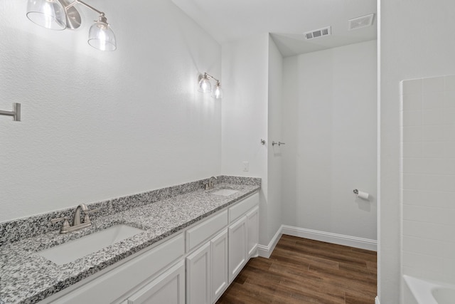 bathroom with vanity, a bathing tub, and hardwood / wood-style floors