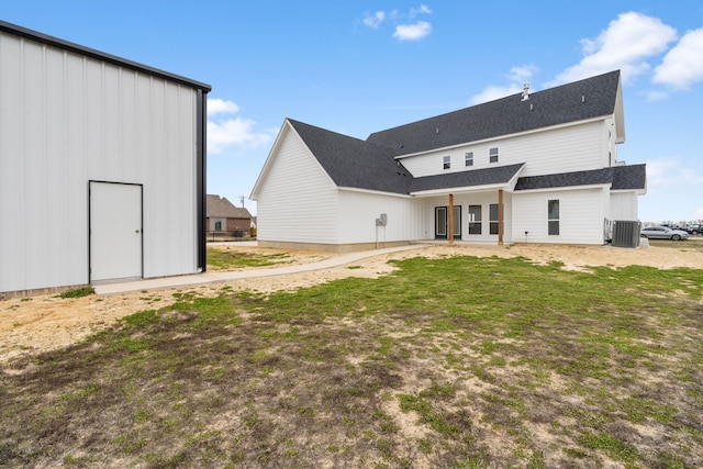 back of house with cooling unit, a patio, a lawn, and an outbuilding