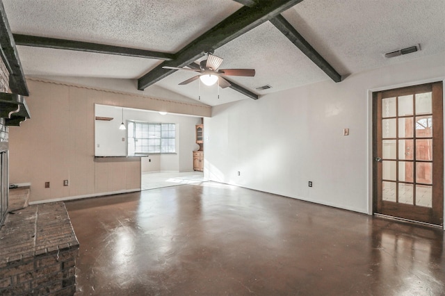 unfurnished living room with lofted ceiling with beams, ceiling fan, concrete floors, and a textured ceiling